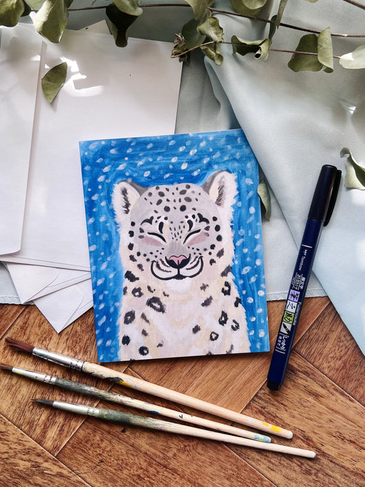 Snow leopard blank note card flat lay with stationary